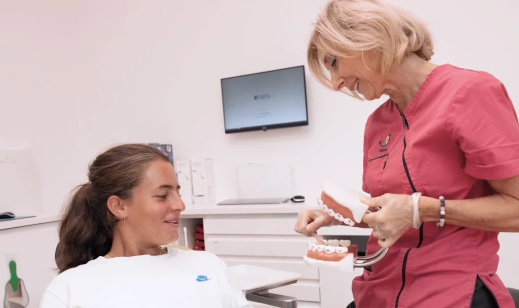 Enfant au fauteuil écoutant les conseils d’hygiène de la praticienne