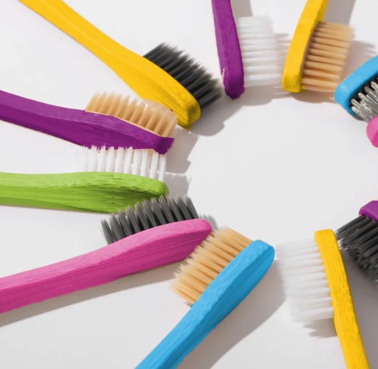 Brosses à dents en bambou colorées disposées en cercle – hygiène bucco-dentaire pendant un traitement orthodontique